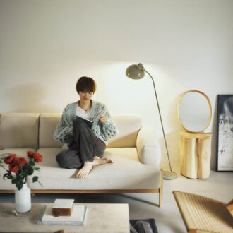 フロアランプ【6556-F】15万5980円(カイザー・イデル)、手縫いされたレザーフレームにレトロなオーバル型ミラーをセット。オーバルミラー3万6300円(モヘイム)、テーブルの上のフラワーベース1万7600円(ジュー/すべてアクタス) ニットカーディガン11万円(ミスターミトンズ/RHC ロンハーマン) パンツ2万8600円、スリッパ1万4300円(ともにベアフット ドリームズ/リトルリーグ インク) タンクトップ5940円(サク・レ/ロイネ) ネックレス10万5600円(グレイン モートン/ロンハーマン)