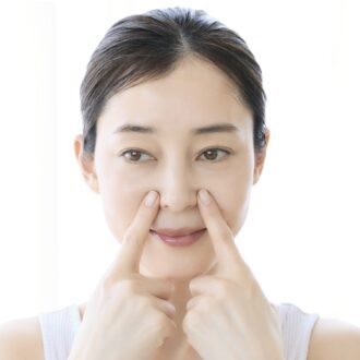 鼻の横のツボを押す