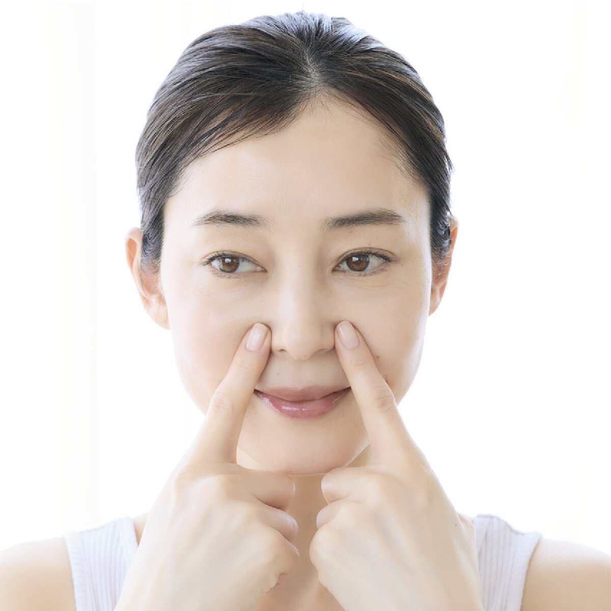 鼻の横のツボを押す