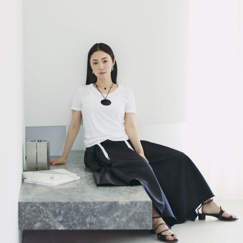Tシャツ8800円（ミースロエ／MIESROHE ルミネ新宿1店）　中に来たガータータンク7480円（オーバーニース）、ピアス4万6200円（エルエルシー／ともにザニーム）　スカート5万5000円（サードマガジン）　チョーカー13万2000円（アサミ フジカワ／ショールーム セッション）　コードネックレス21万8900円（ソフィー ブハイ／エスケーパーズ アナザーワールド）　サンダル5万600円（カチム）