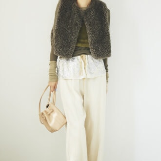 ふわモコのベストとカーキの濃淡を切り替えたカットソーをレイヤード。シャイニーな飾りがついたベージュのパンツで軽やかに。ベスト3万9600円(ハイク/ボウルズ) ファービスチェ3万800円(フミエタナカ/ドール) カットソー2万4200円、パンツ4万2900円(ともにミュラー オブ ヨシオクボ) バッグ4万4000円(ヴァジック/ヴァジックジャパン) ミュール3万円(バナナ・リパブリック)