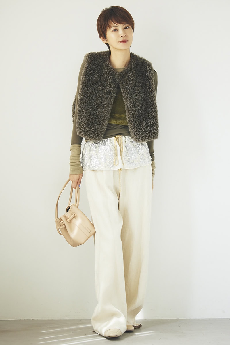 ふわモコのベストとカーキの濃淡を切り替えたカットソーをレイヤード。シャイニーな飾りがついたベージュのパンツで軽やかに。ベスト3万9600円(ハイク/ボウルズ) ファービスチェ3万800円(フミエタナカ/ドール) カットソー2万4200円、パンツ4万2900円(ともにミュラー オブ ヨシオクボ) バッグ4万4000円(ヴァジック/ヴァジックジャパン) ミュール3万円(バナナ・リパブリック)