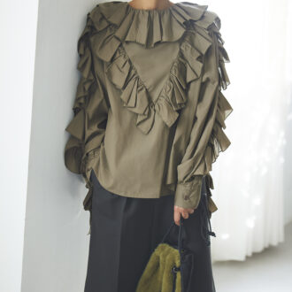 ボリューミーなフリルをたっぷり重ねたデザインが、ミリタリー感を完全に払拭。逆にカーキだからこそ、甘さがトゥーマッチにならずモードっぽく着こなせる。今っぽくてきれいな美シルエットのハーフパンツで引き締めて、エッジィな甘辛ミックスに。ブラウス3万6300円（ミュラー オブ ヨシオクボ）　パンツ4万8400円（オブリオ）　バッグ3万9600円（ヴァジック／ヴァジックジャパン）