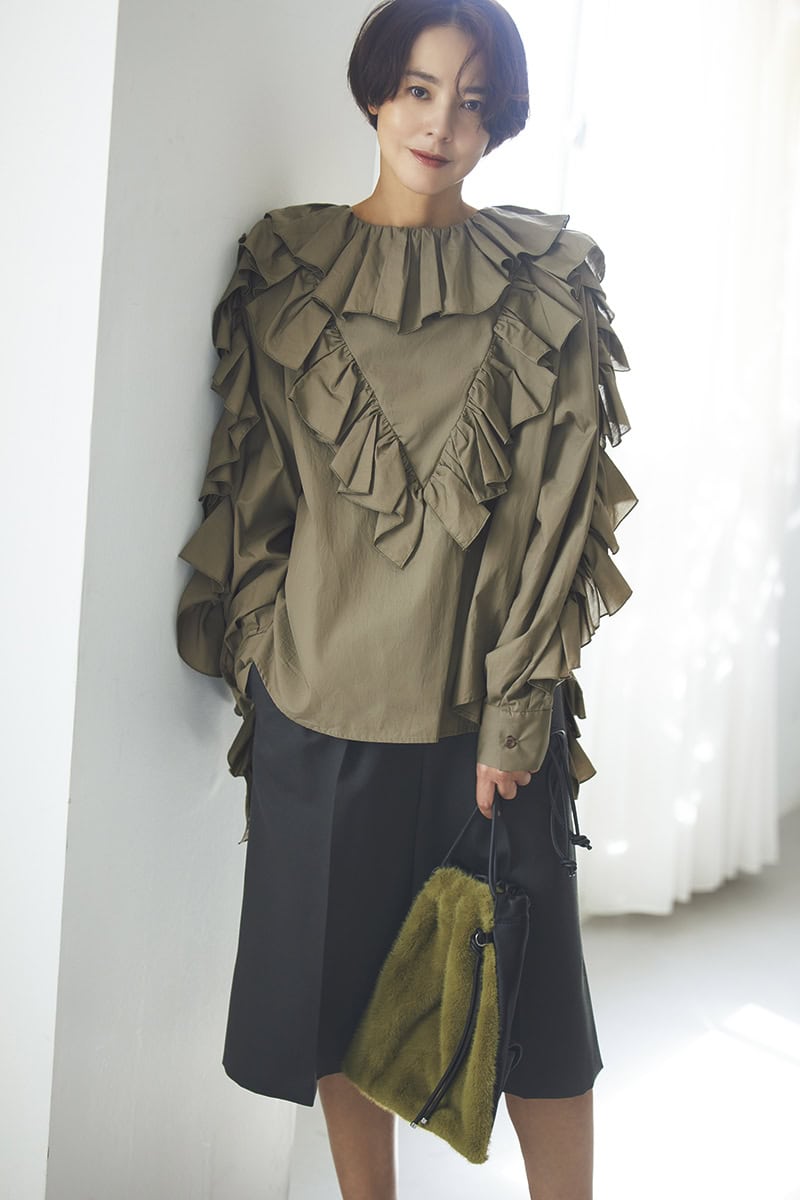 ボリューミーなフリルをたっぷり重ねたデザインが、ミリタリー感を完全に払拭。逆にカーキだからこそ、甘さがトゥーマッチにならずモードっぽく着こなせる。今っぽくてきれいな美シルエットのハーフパンツで引き締めて、エッジィな甘辛ミックスに。ブラウス3万6300円（ミュラー オブ ヨシオクボ）　パンツ4万8400円（オブリオ）　バッグ3万9600円（ヴァジック／ヴァジックジャパン）