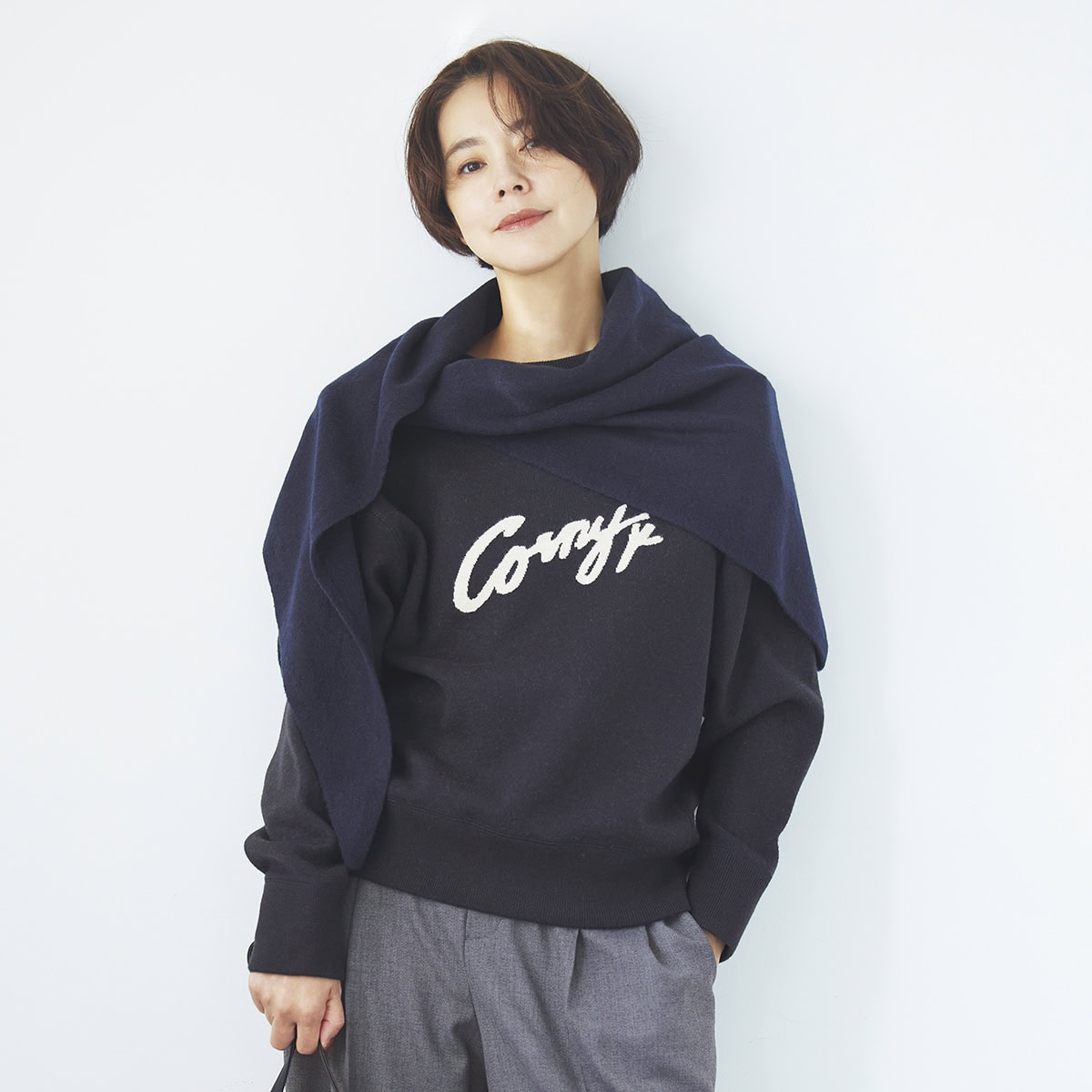 ブルベさんに似合う、青みが際立つ色のネイビーのコーデ。同色のニットとストールで上半身をまとめてすっきりと。