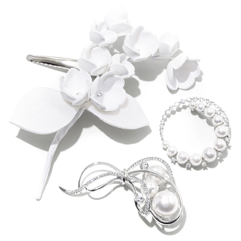 上_淡色のスーツと好相性。コサージュ1万2100円（ヴァンドームブティック／ヴァンドームブティック 大丸東京店）　右_モダンなサークル形。ブローチ2万2000円、下_曲線的なラインが優しげ。ブローチ2万5300円（ともにヴァンドームブティック／ヴァンドームブティック 大丸東京店）