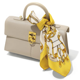 手軽に品よくお洒落な雰囲気を醸し出せるスカーフは、首もとだけでなくバッグのハンドルに巻くのも◎。バッグ9万2200円(カフネ) 巻いたスカーフ7700円(アンタイトル)