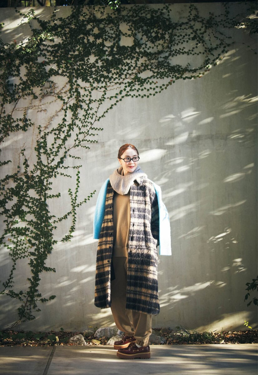 コート27万5000円（オブリオ）　スエット2万8600円、パンツ3万800円（ともにハイク／ボウルズ）　肩にかけたニット3万9600円（プレインピープル／プレインピープル青山）　バラクラバ7700円（リット／ピモンテ）　靴2万5300円（ティンバーランド／VF ジャパン）　メガネ5万2580円（ミュウミュウ／ルックスオティカジャパン カスタマーサービス）　ピアス16万5000円（カジャビジュー）