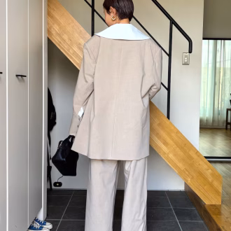 やわらかなベージュのセットアップに、ビッグカラーで抜け感を