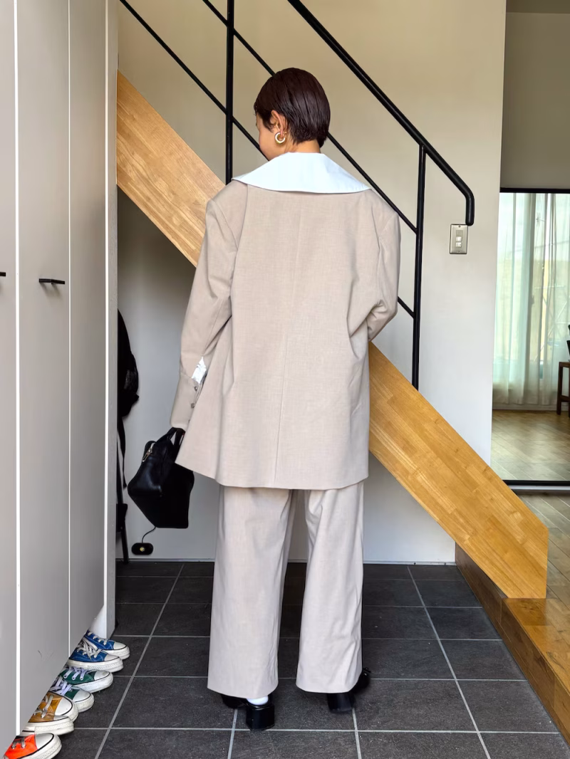 やわらかなベージュのセットアップに、ビッグカラーで抜け感を