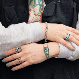 「マニッシュな着こなしになじむよう、寒色系ストーンのシルバーカラーアクセサリーで、手もとをクールにまとめました」