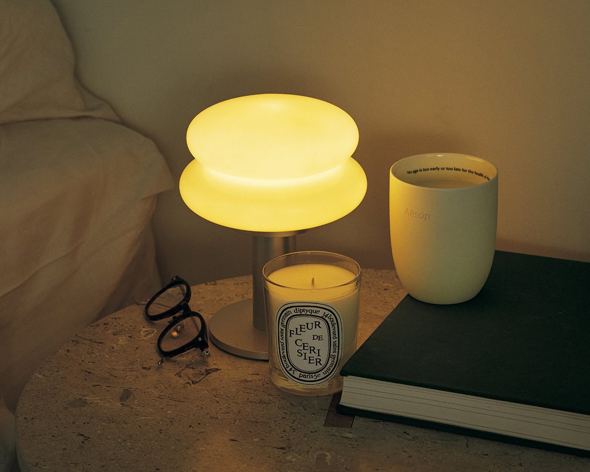 手前左：春の到来を告げる、桜が主役。ディプティック フルール ド スリジエ 190g 1万450円（ディプティック ジャパン）※3月5日限定発売　中：3段階の明るさに調節でき、ベッドサイドのランプに最適。ILKW. SNOWMAN 15 ポータブルランプ 1万9800円（アクタス）　右：日本の原生林を想起させるアーシーでウッディな香り。イソップ プレトミー アロマティックキャンドル 300g 1万4960円（イソップ）